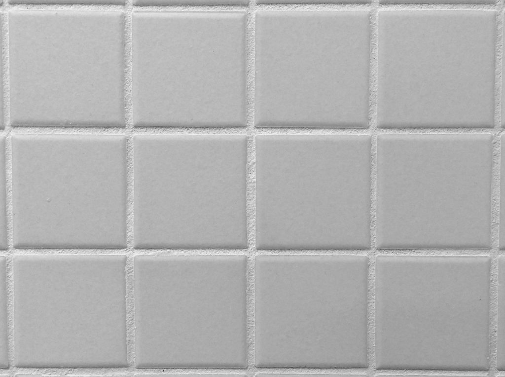 Close-up of dirty and clean grout between floor tiles
