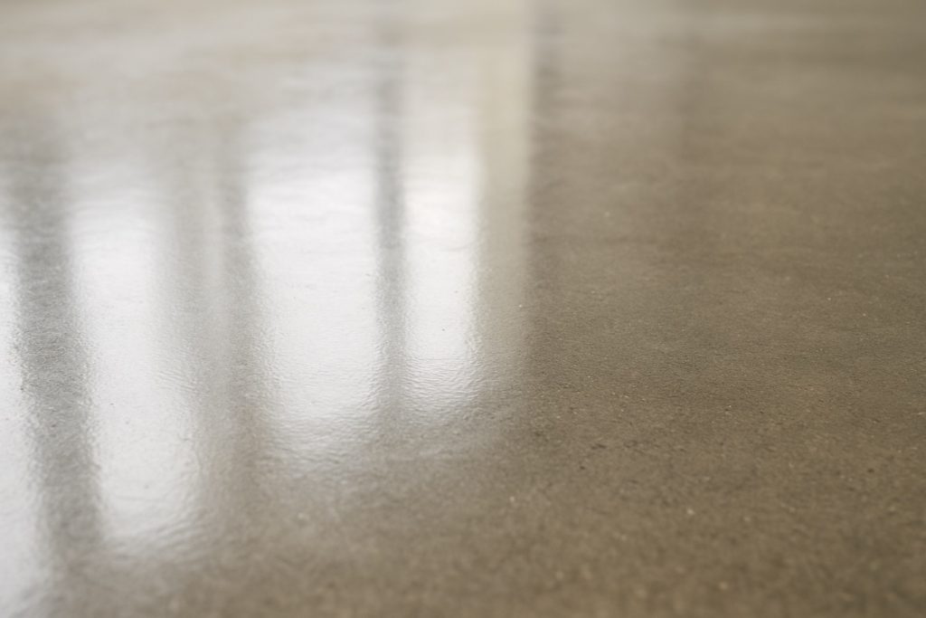 Close-up of a polished concrete floor showing a glossy, reflective shine after buffing.